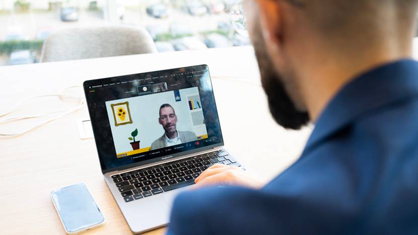 Man zit achter een laptop en heeft een online meeting.