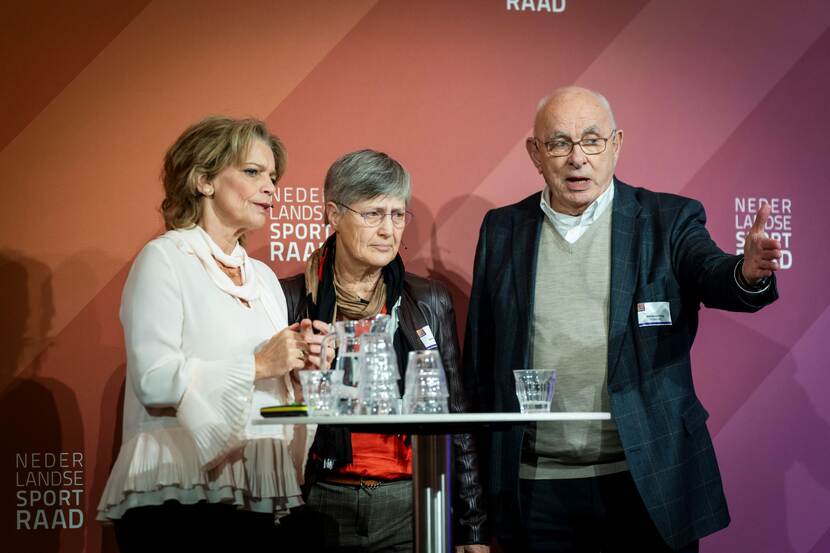 Foto van dagvoorzitter Inge Diepman samen met Leanne van den Hoek en Michael van Praag tijdens het NLsportraad symposium Bewegen in de Haagse werkelijkheid op 13 december 2023