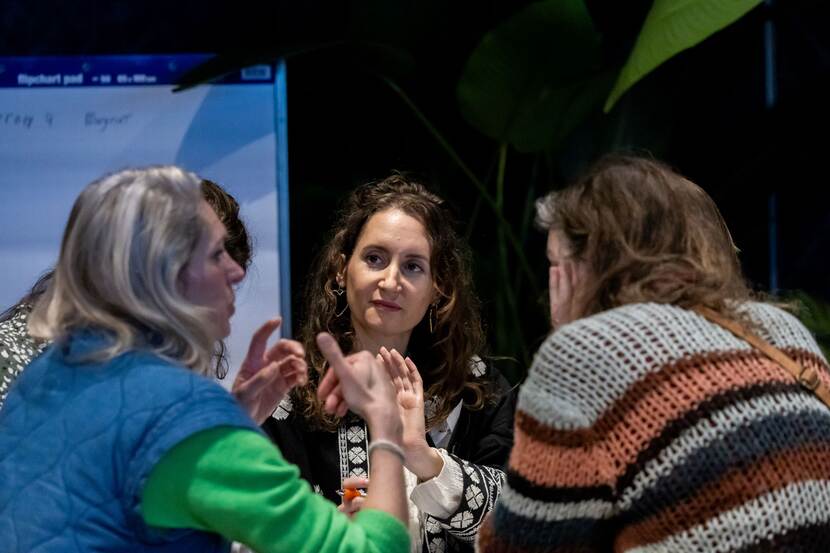 Vier vrouwen met elkaar in gesprek tijdens bijeenkomst van de Nederlandse Sportraad op 11 februari