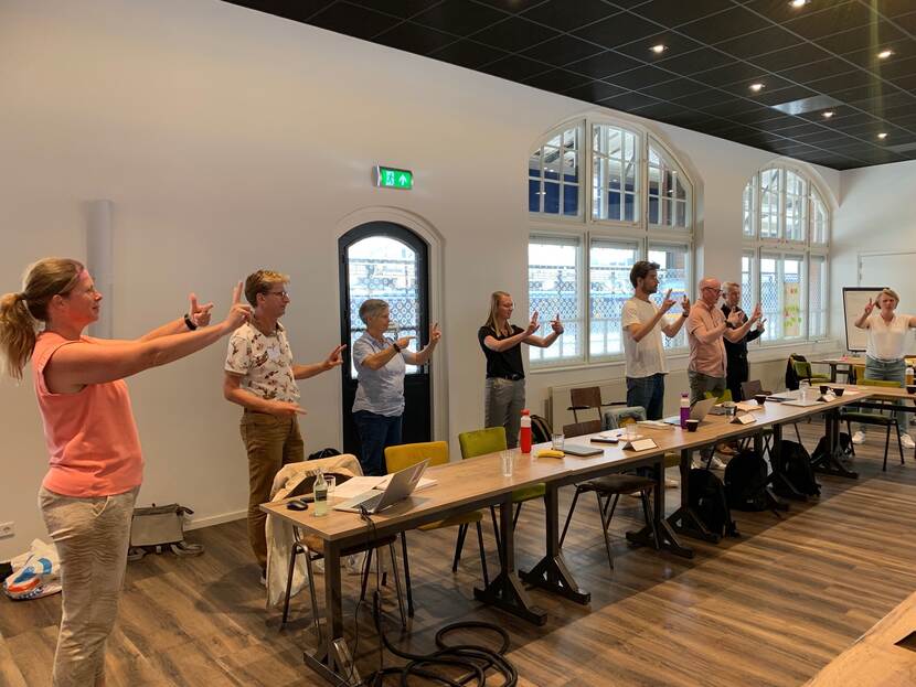 Foto van een bijeenkomst over bewegen tijdens de levensloop met mensen die een oefening doen