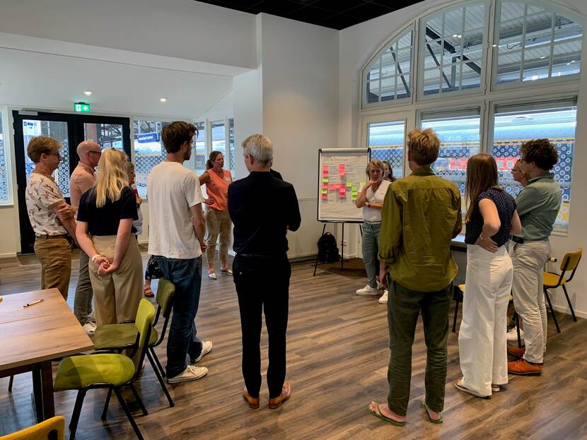 Foto bijeenkomst mensen die staan in een kring die met elkaar in gesprek zijn over bewegen tijdens de levensloop