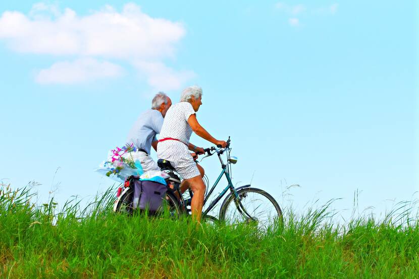 Twee oudere mensen op de fiets